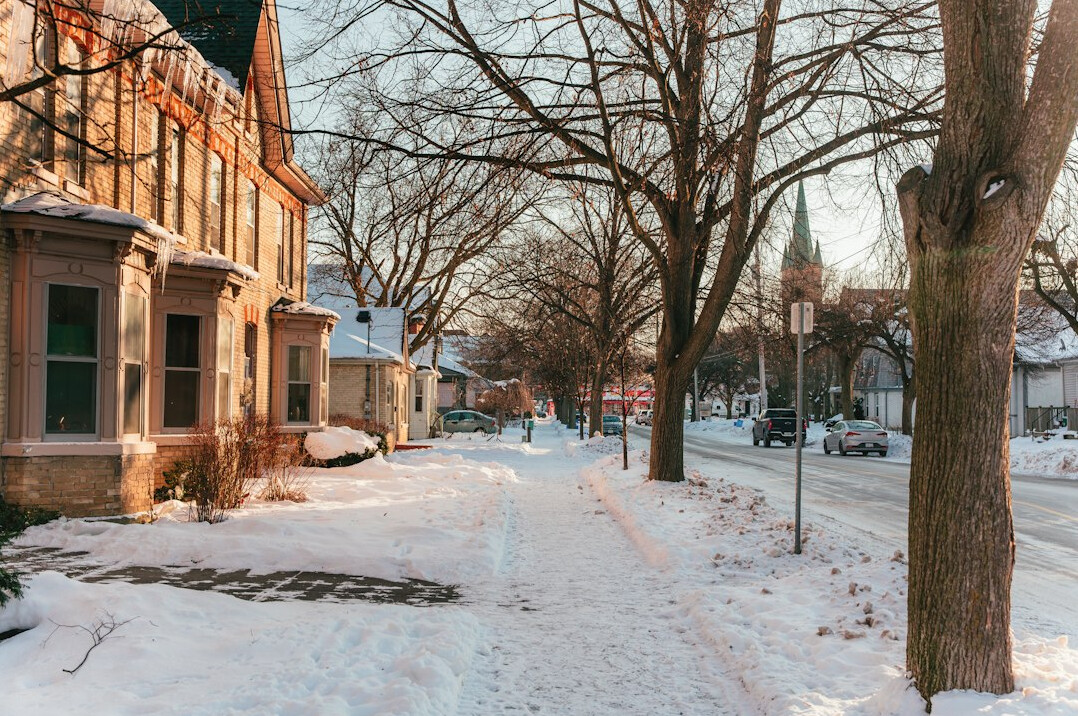 Snow covered sidewalk along a row of houses in winter