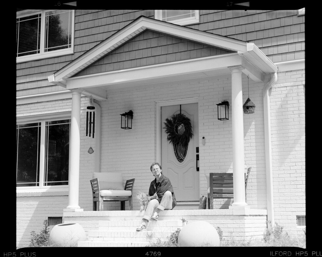 Two neighbors chatting on a front porch